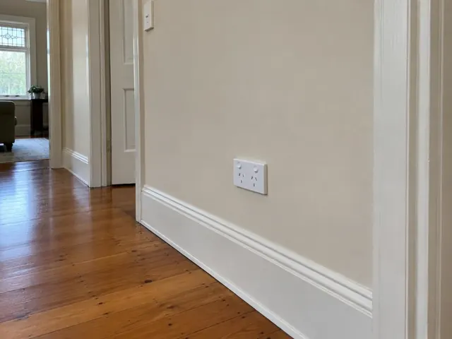 White power point on a painted hallway wall with timber floorboards and period trim in Pymble
